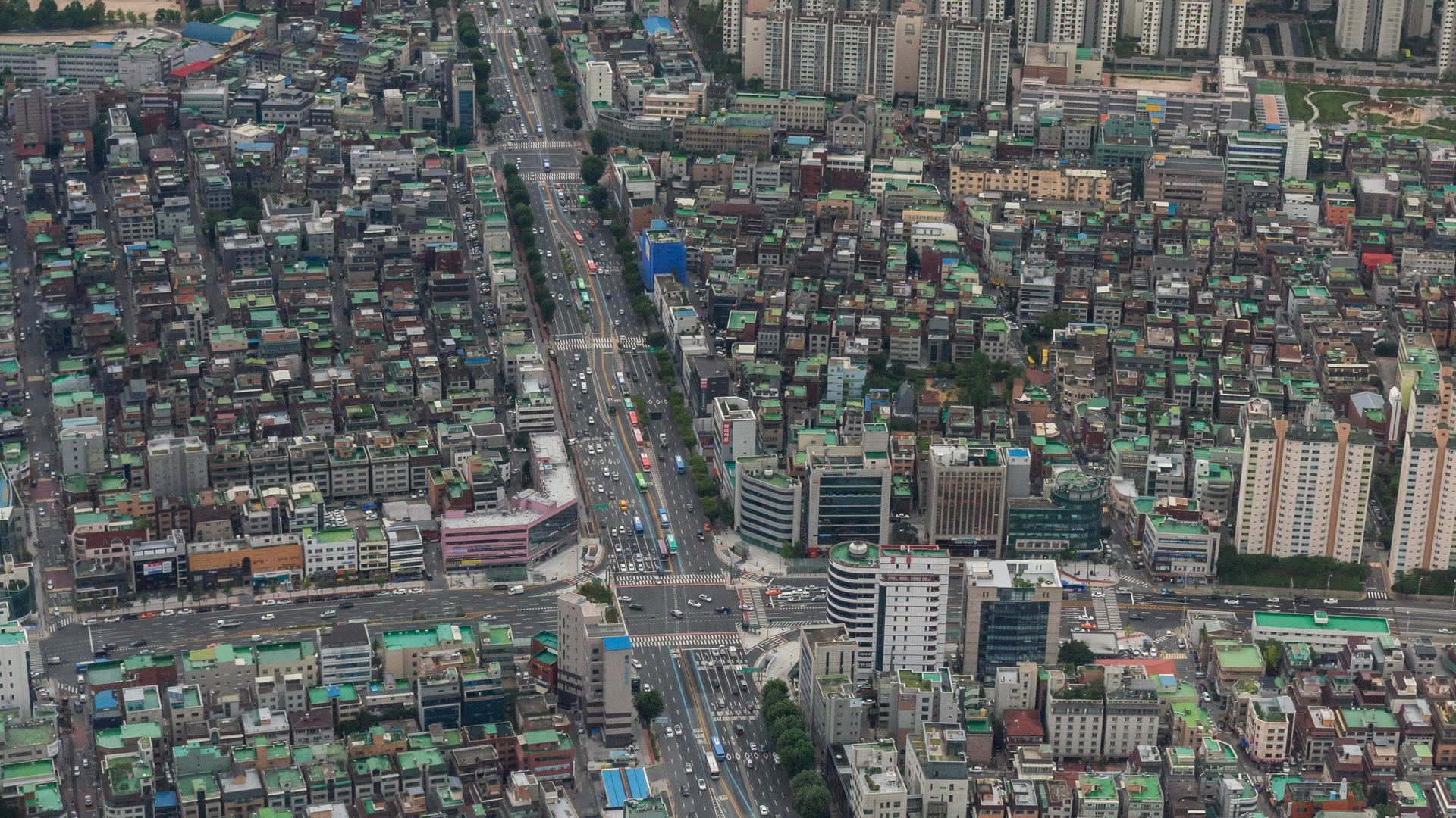 Aerial view of Songpa-daero and the Songpa-gu district in Seoul, with apartment towers and the Lotte World Tower in the distance.